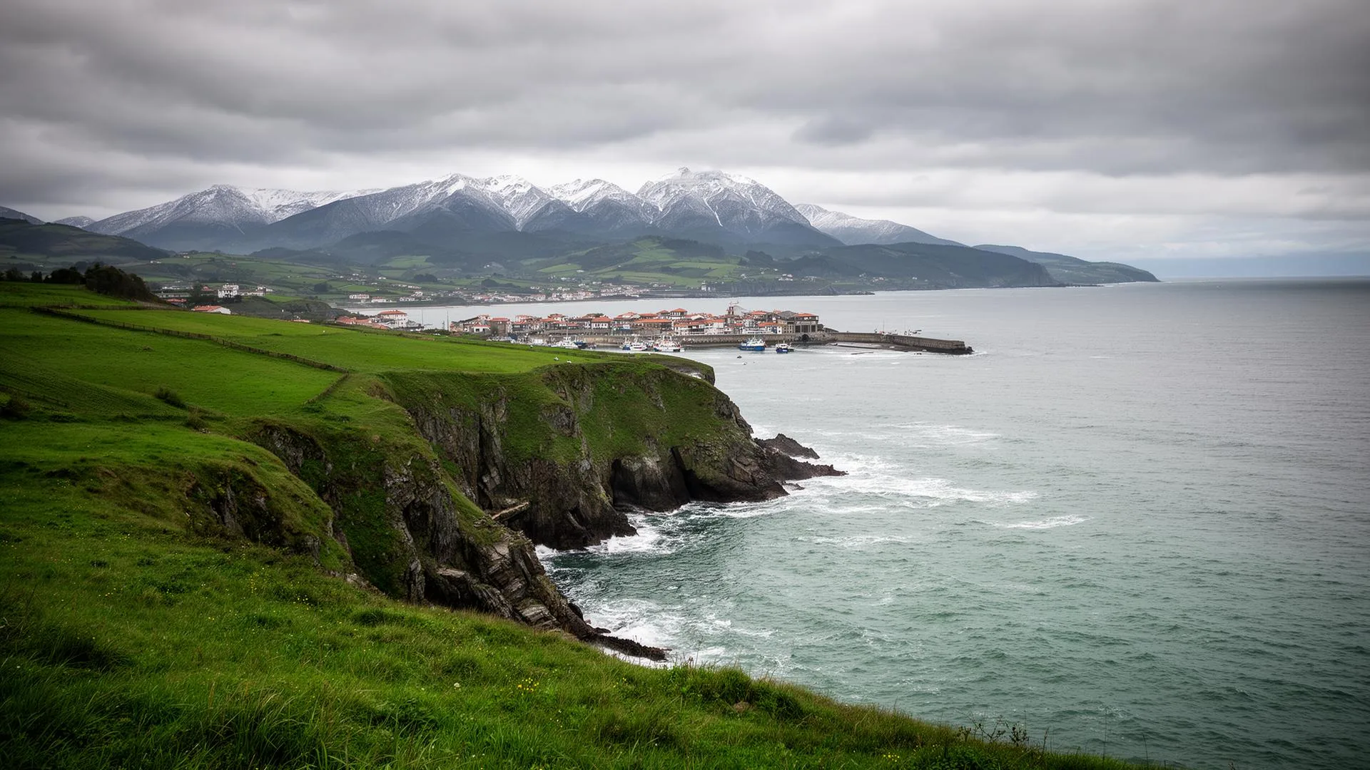 Paisaje del Cantábrico: mar, prados verdes y montañas al fondo